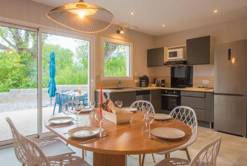 une cuisine et une salle à manger avec une table et des chaises en bois dans l'établissement Villas Pelvoux Aster, à Guillestre