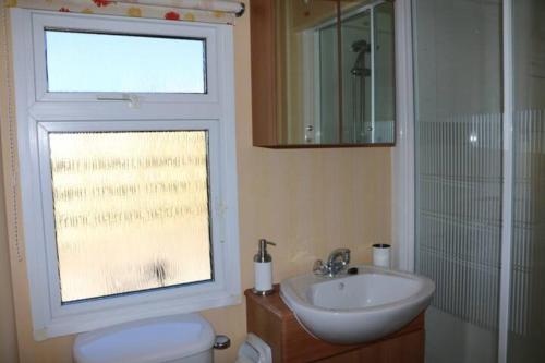 a bathroom with a toilet and a sink and a window at Heaste Retreat in Broadford