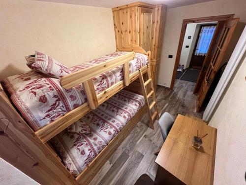 2 Etagenbetten in einem Zimmer mit einem Tisch in der Unterkunft Chalet Chez Louis vista Catena Monte Bianco sulle piste da sci in Courmayeur