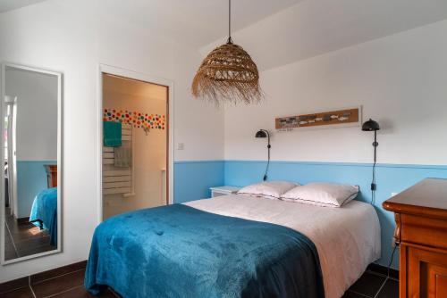 1 dormitorio con 1 cama con paredes azules y blancas en Killiouarn - Charmante maison à 15min des plages, en Gouesnach