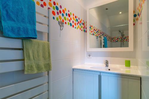 y baño con lavabo y espejo. en Killiouarn - Charmante maison à 15min des plages, en Gouesnach