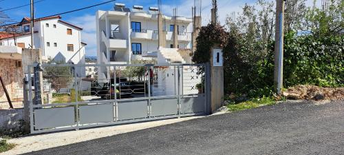 a gate on the side of a road next to a building at Guest House Bledar in Ksamil