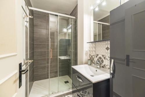 een badkamer met een glazen douche en een wastafel bij L’Escapade Bretonne - Appt à 10min de la plage in Saint-Brieuc