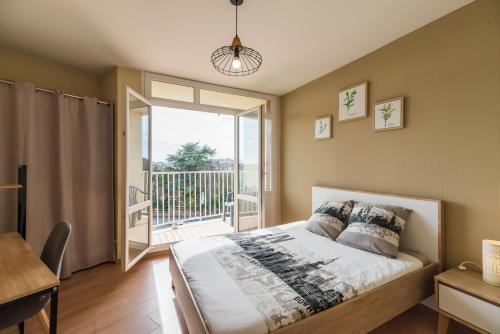 een slaapkamer met een bed en een balkon bij L’Escapade Bretonne - Appt à 10min de la plage in Saint-Brieuc