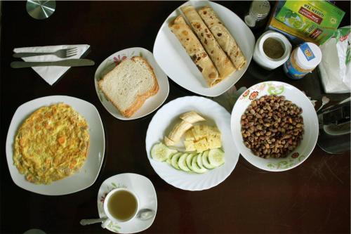 a table with plates of food and cups of coffee at Catherine home near kilimanjaro international airport JRO in Moshi