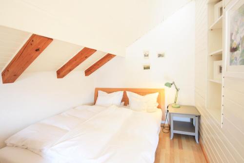a bedroom with a white bed in a attic at Ferienwohnungen Roseninsel & Perle in Feldafing