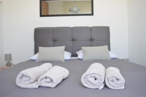 a bed with white towels on top of it at Central Apartments Preko in Preko