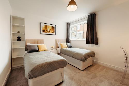 a bedroom with two beds and a window at Sophisticated 2BR retreat for Contractors in charming Hinckley in Hinckley