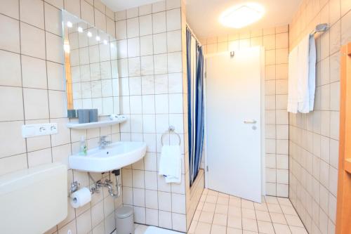 a bathroom with a sink and a toilet and a shower at Ferienwohnungen Roseninsel & Perle in Feldafing