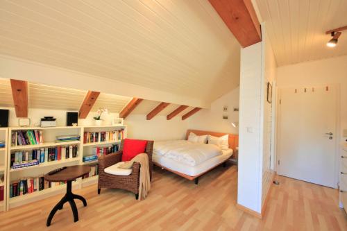 a bedroom with a bed and a book shelf at Ferienwohnungen Roseninsel & Perle in Feldafing