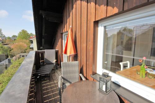 a balcony with a table and chairs and a window at Ferienwohnungen Roseninsel & Perle in Feldafing