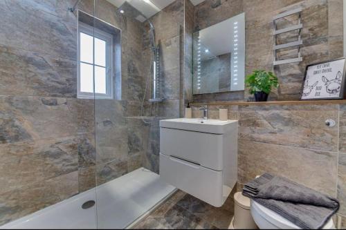La salle de bains est pourvue de toilettes, d'un lavabo et d'un miroir. dans l'établissement “Hot Tub, Private Parking, Beachside Luxury”, à Cleethorpes