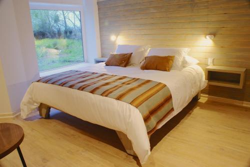 un grande letto in una camera da letto con finestra di Barrica Lodge a Santa Cruz