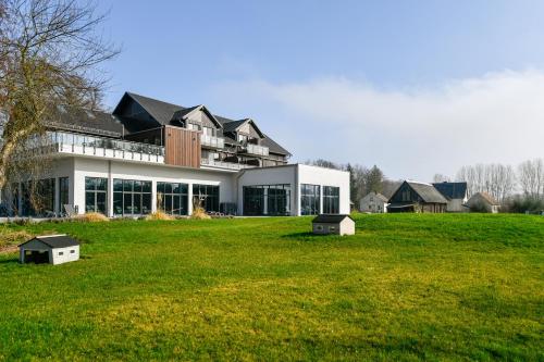a large building with a green field in front of it at Landhotel Burg im Spreewald - Resort & Spa in Burg
