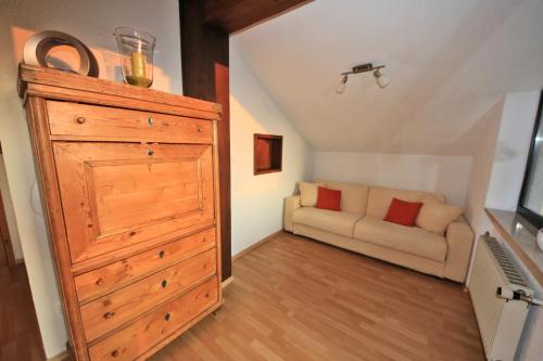 a living room with a large dresser and a couch at Ferienwohnungen Roseninsel & Perle in Feldafing