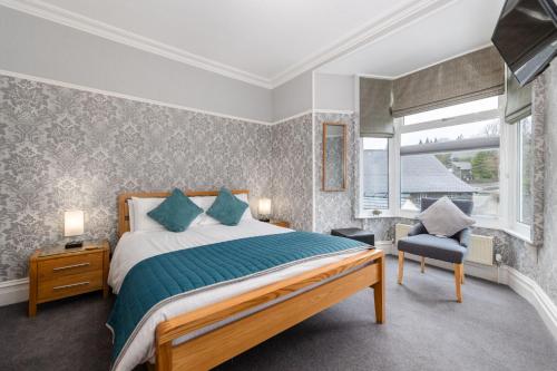 a bedroom with a bed and a chair and a window at Thornbank House Offering Breakfast and with Free Off Site Health Club in Windermere