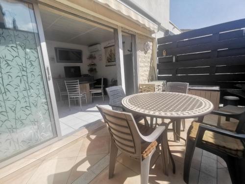 un patio avec une table et des chaises sur un balcon dans l'établissement 5039 Tennis Village 308, au Cap d'Agde