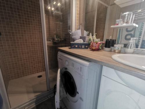 une salle de bain avec une machine à laver et un lavabo dans l'établissement 5039 Tennis Village 308, au Cap d'Agde