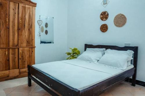 a bedroom with a bed with a wooden headboard at Digital nomad Cave- Zanzibar in Stone Town