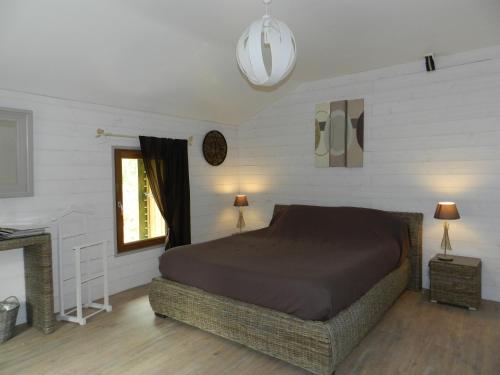 - une chambre avec un grand lit et une cheminée dans l'établissement HERMITAGE DURAS, à Anzex