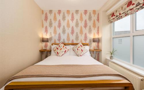a small bedroom with a bed and a window at Thornbank House Offering Breakfast and with the use of Free Local Health Club in Windermere