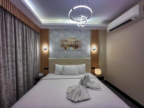 杜拜的住宿－GOLD SKY AVENUE HOTEL，一间卧室配有一张床和一个吊灯