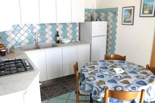 a kitchen with a table and a white refrigerator at Vent In Costa Ospitalità Diffusa in Furore