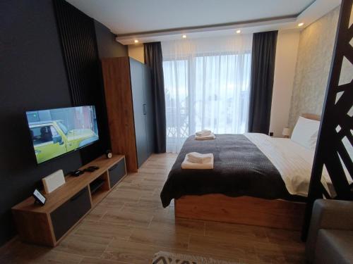 a bedroom with a bed and a flat screen tv at XL apartments, Residence Hill, Kopaonik in Kopaonik