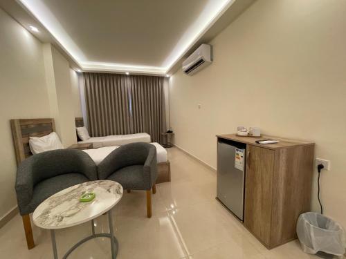 Habitación de hotel con cama, mesa y sillas en Aster Hotel Aqaba, en Áqaba