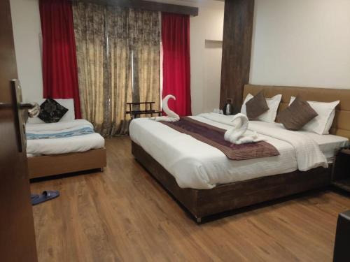 sypialnia z dużym łóżkiem z dwoma łabędzami w obiekcie Hotel Green Leaf , Srinagar w mieście Śrinagar