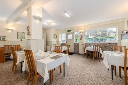 a dining room with white tables and chairs at Thornbank House Offering Breakfast and with the use of Free Local Health Club in Windermere