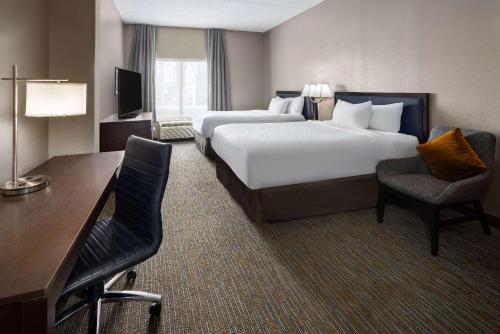 a hotel room with two beds and a desk at La Quinta Inn & Suites by Wyndham Mooresville in Mooresville
