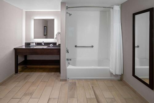 a bathroom with a tub and a sink and a shower at La Quinta Inn & Suites by Wyndham Mooresville in Mooresville