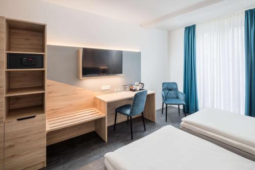 a hotel room with a desk and a bed at Best Western Hotel Lippstadt in Lippstadt