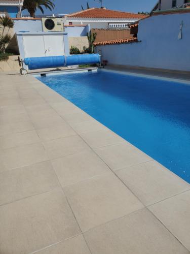 een zwembad naast een huis bij Villa Sunrise with heated pool. in Callao Salvaje