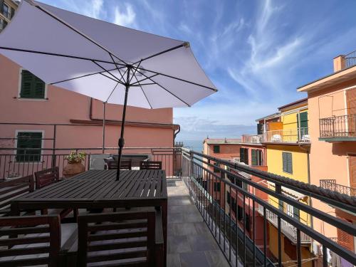 a table with an umbrella on a balcony at Luxury Apartments Manarola by Arbaspàa in Manarola