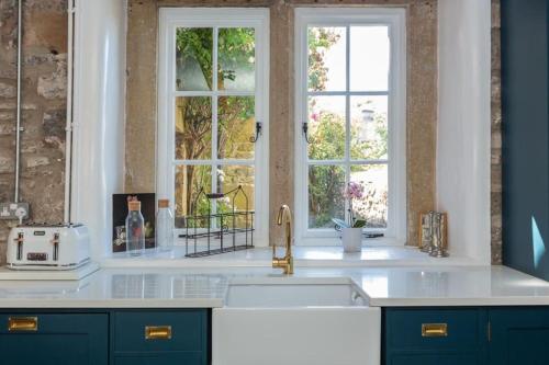 a kitchen with a sink and a window at Beautifully Renovated Old Sweet Shop in Youlgreave