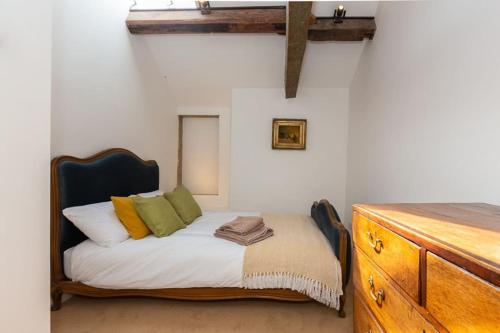 a bedroom with a bed and a wooden dresser at Beautifully Renovated Old Sweet Shop in Youlgreave