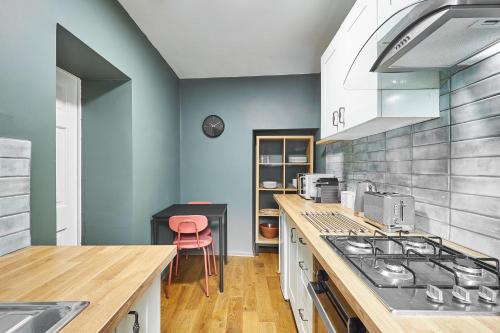 Host & Stay - Thorne Cottage في ستانهوب: مطبخ بجدران زرقاء وكاونتر مع موقد