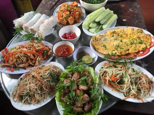 una mesa con muchos platos de comida. en Homestay Long Coc, en Phú Thọ