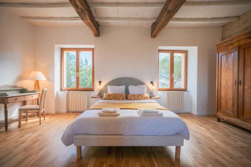 a large bedroom with a large bed and a piano at Chambres et table d'hôtes - Les Jardins de la Longagne in Saussenac