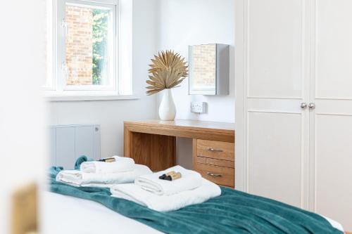 łazienka z dwoma ręcznikami na łóżku w obiekcie Lit & airy 2BR Flat wparking & balcony, Wimbledon w Londynie