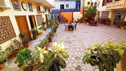 ANAND LOK VATIKA في راجغوري: ساحة مع طاولات ونباتات خزف في مبنى