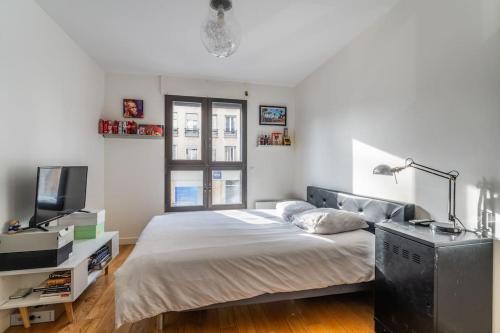 - une chambre avec un lit et une télévision dans l'établissement Appartement Moderne familial, à Saint-Mandé