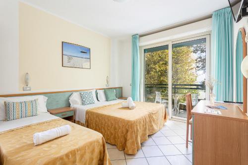 Habitación de hotel con 2 camas y ventana en Hotel Gadames - Lunch on the Beach, en Cervia