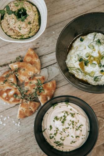 a table with a plate of dip and some food at The Bay Hotel & Suites in Vasilikos