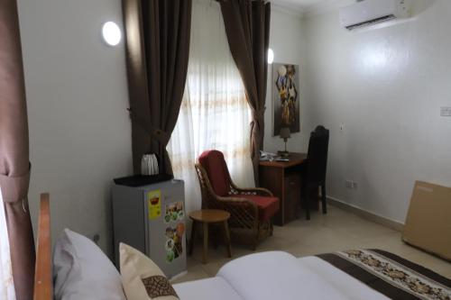 ein Hotelzimmer mit einem Bett, einem Stuhl und einem Fenster in der Unterkunft NYASAPO ECO RESORT in Mouri