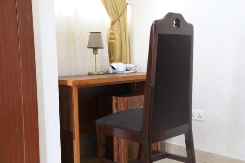 a wooden desk with a chair next to a room at NYASAPO ECO RESORT in Mouri