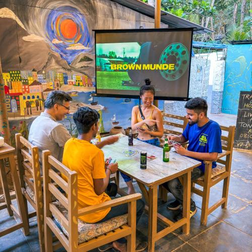 a group of people sitting around a table playing a video game at Traverse Luxe Hostel Palolem in Palolem