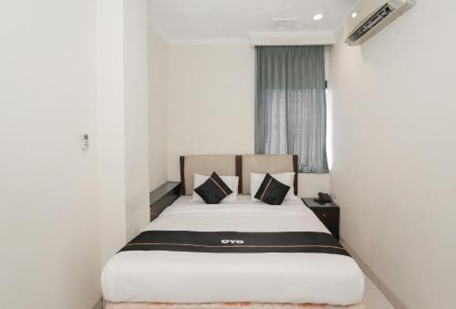 um quarto de hotel com uma cama num quarto em Townhouse Oak J&b Gunung Sahari em Jakarta